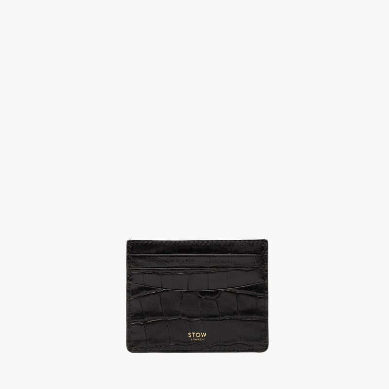 STOW London's Cardholder in Black Embossed Croc leather on a light grey background featuring a fine gold embossed logo on the front bottom. 