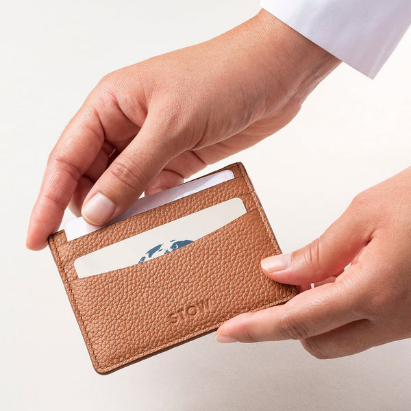 STOW Leather Cardholder in Earth Tan colour being held by model.