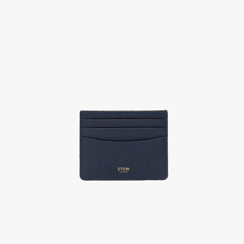 STOW London's Cardholder in Navy pebbled leather on a light grey background featuring a fine gold embossed logo on the front bottom. 