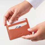 STOW Leather Cardholder in Clay Orange colour being held by model.