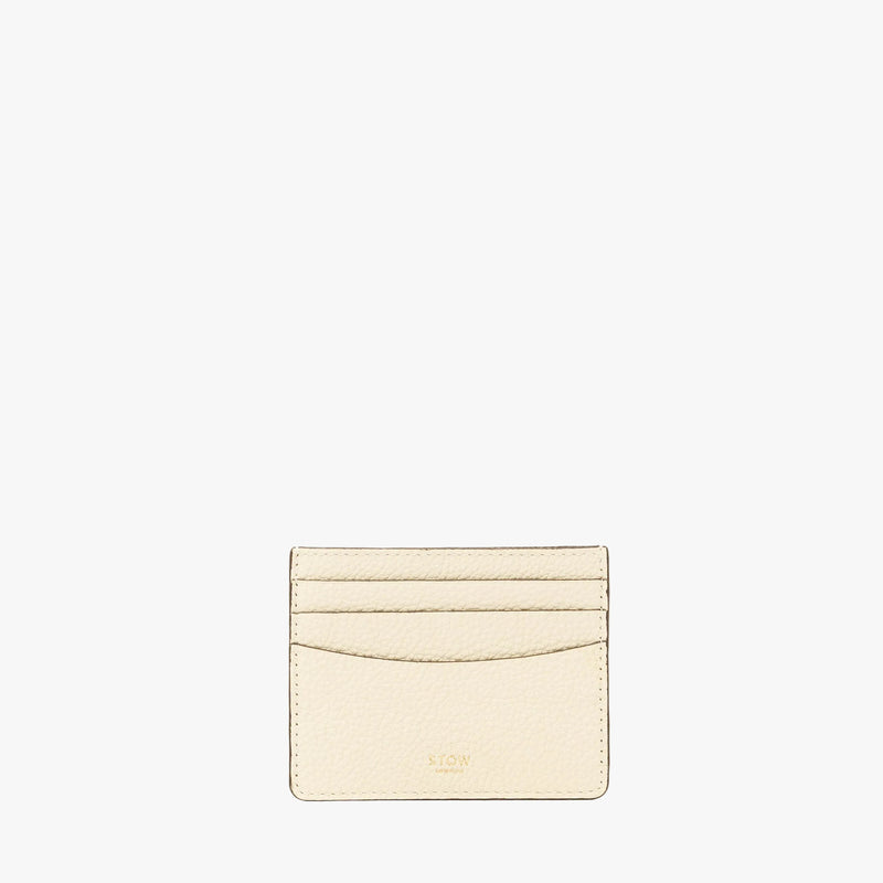 STOW London's Cardholder in Spring Moon pebbled leather on a light grey background featuring a fine gold embossed logo on the front bottom. 