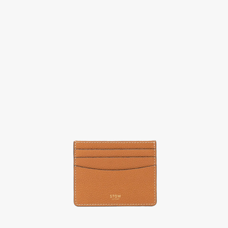 STOW London's Cardholder in Earth Tan pebbled leather on a light grey background featuring a fine gold embossed logo on the front bottom. 