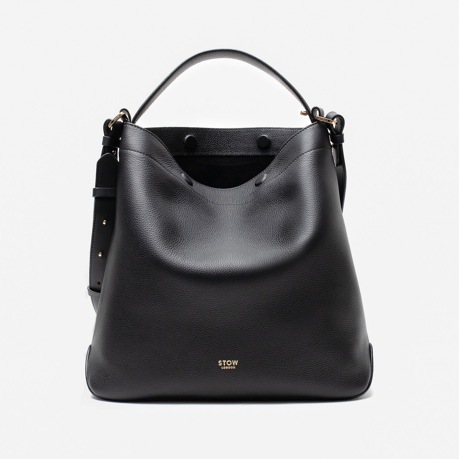 STOW London's Curve bag in Black pebbled leather with magnets open showing the black suede interior lining featuring gold-coated stainless steel hardware on a light grey background