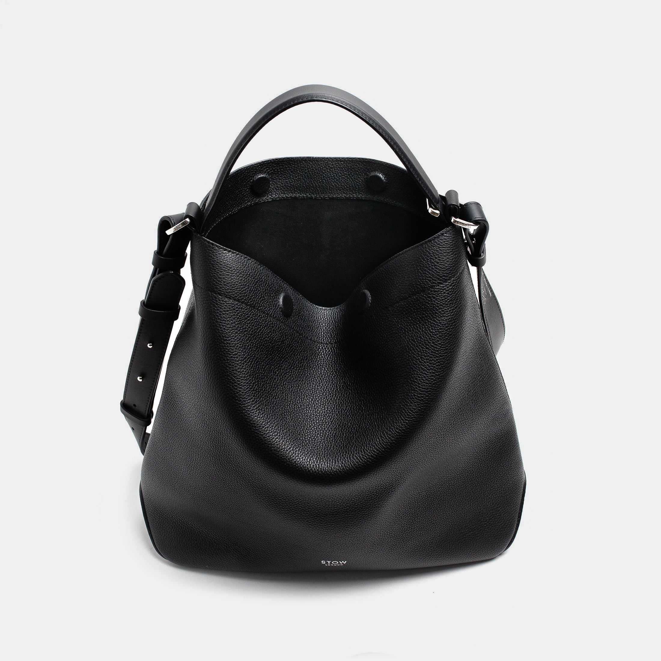 STOW London's Curve bag in Black pebbled leather with magnets open the black suede interior lining featuring silver stainless steel hardware on a light grey background