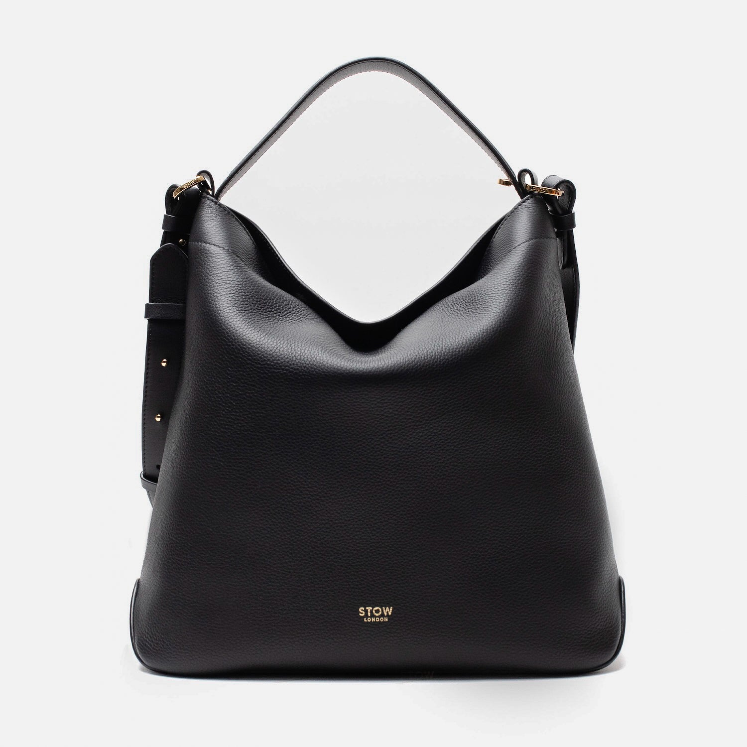 Stow London's Curve bag in Black pebbled leather featuring gold-coated stainless steel hardware on a light grey background