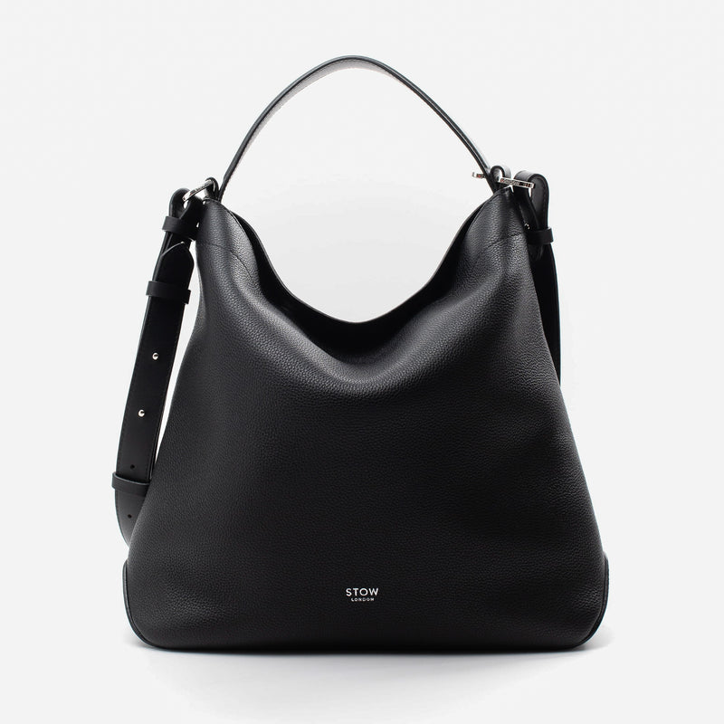 Stow London's Curve bag in Black pebbled leather featuring silver stainless steel hardware on a light grey background