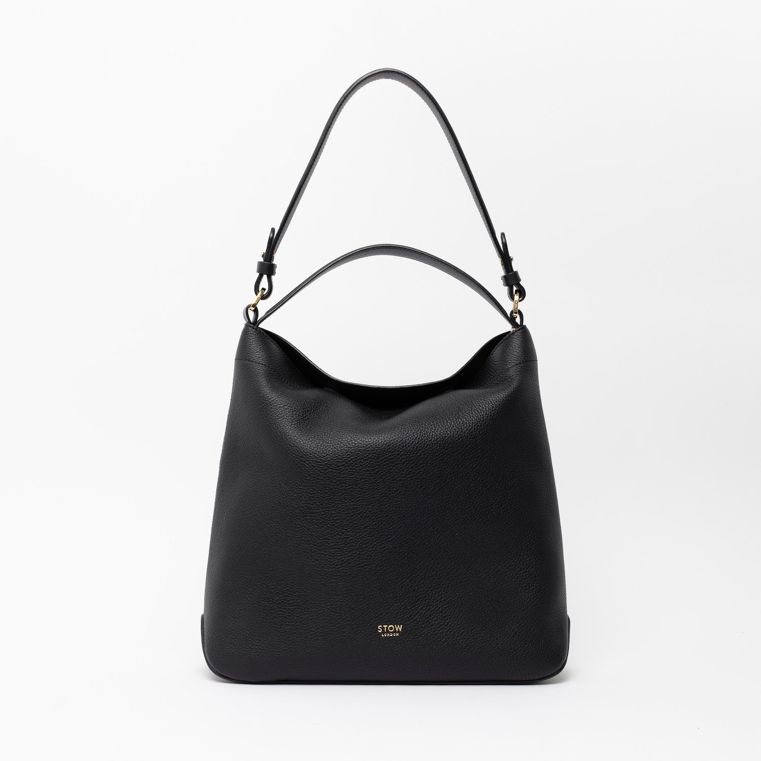 STOW London's Curve in Black leather on a light grey background featuring the detachable shoulder strap and top handle with gold hardware and details 
