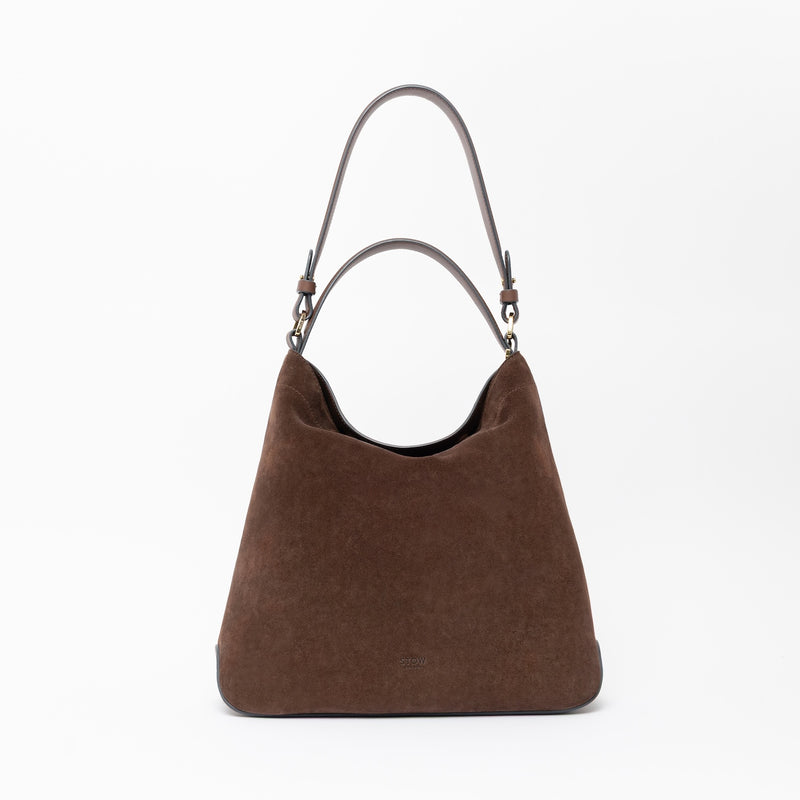 STOW London's Curve in Black leather on a light grey background featuring the detachable shoulder strap and top handle with gold hardware and details 