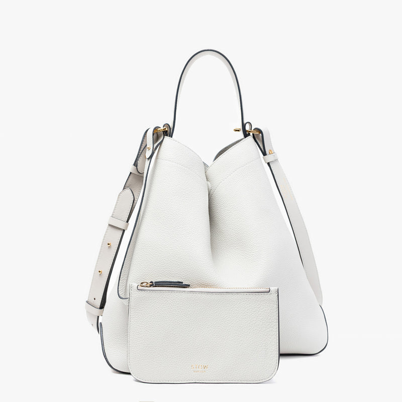 Stow London's Curve bag in Cloud Grey pebbled leather featuring the matching, detachable interior pouch and gold-coated stainless steel hardware on a light grey background