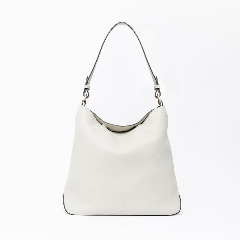 STOW London's Curve in Cloud Grey leather on a light grey background featuring the detachable shoulder strap with gold hardware and details 