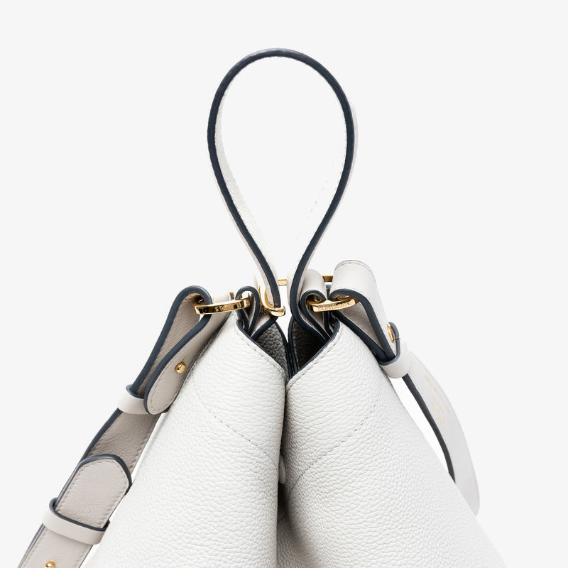 Close-up of the handle on Stow London's Curve bag in Cloud Grey pebbled leather featuring gold-coated stainless steel hardware and clip on a light grey background
