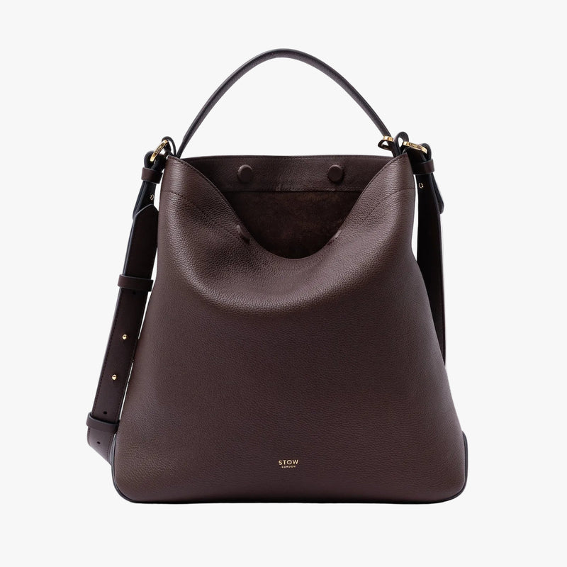 STOW London's Curve Bag in Espresso pebbled leather with magnets open showing the chocolate suede interior lining featuring the detachable crossbody strap and gold-coated stainless steel hardware on a light grey background