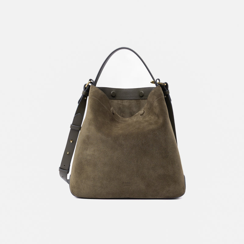 Stow London's Curve bag in Dark Green suede leather featuring gold-coated stainless steel hardware on a light grey background