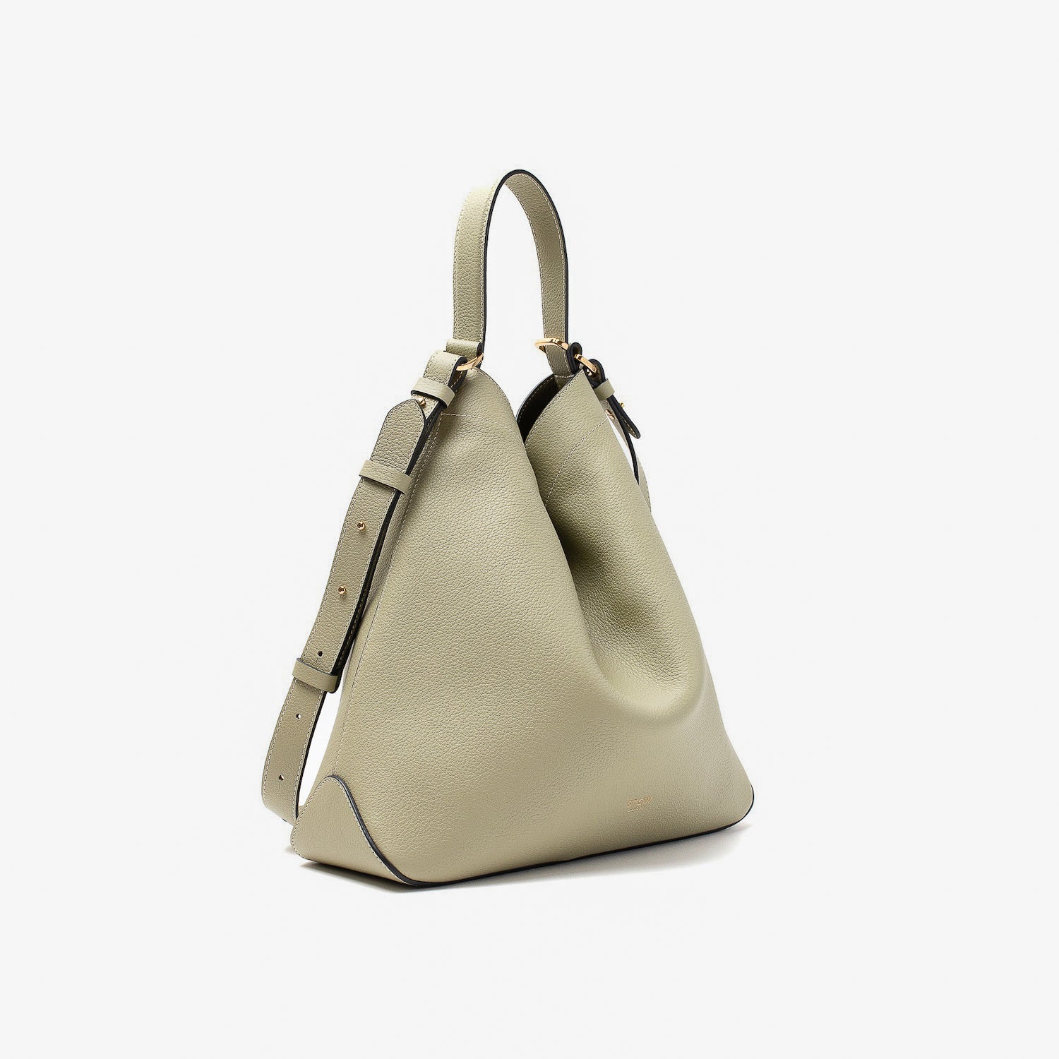 Off-axis view of Stow London's Curve bag in Pale Green pebbled leather shaped in a triangular form featuring gold-coated stainless steel hardware on a light grey background