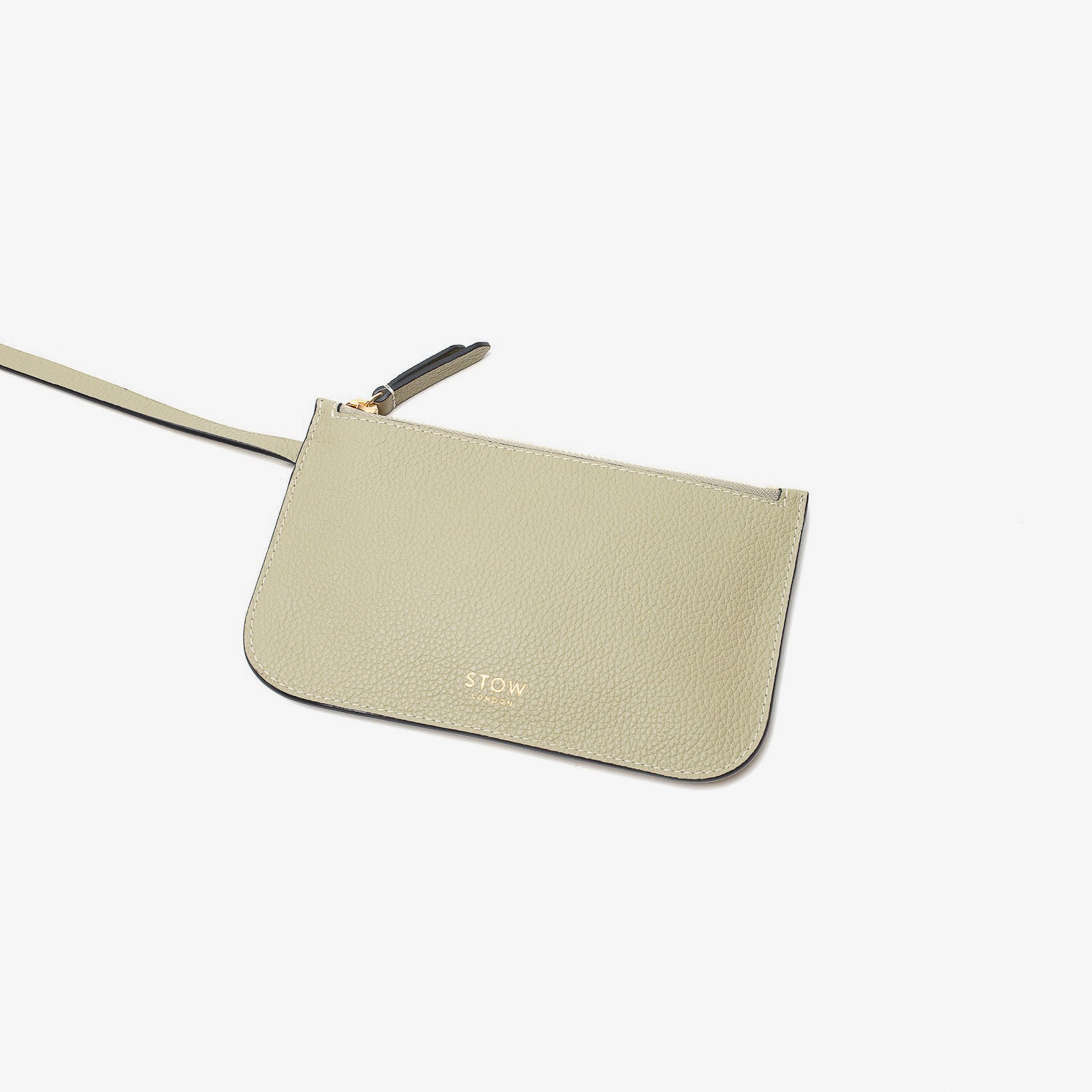 Close up of detachable, interior pouch of Stow London's Curve bag in Pale Green pebbled leather on a light grey background
