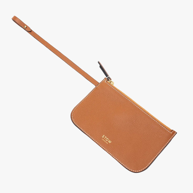The detachable internal pouch from STOW London's Curve Bag in Earth tan pebbled leather on a light grey background featuring a light gold embossed logo