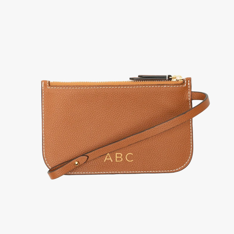 The detachable internal pouch from STOW London's Curve Bag in Earth tan pebbled leather on a light grey background featuring light gold embossed initials