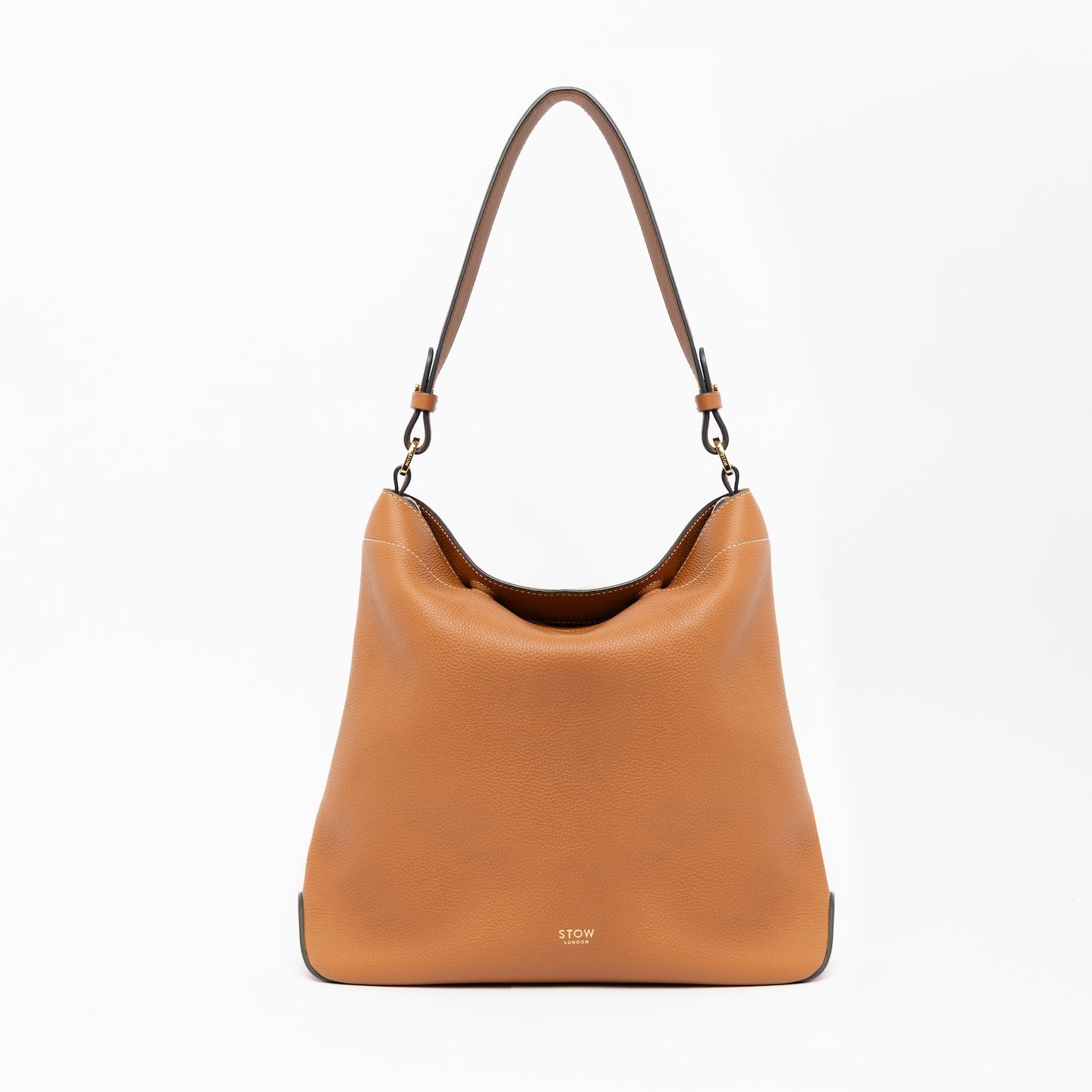 STOW London's Curve in Earth Tan leather on a light grey background featuring the detachable shoulder strap with gold hardware and details 