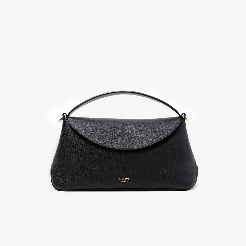 STOW London's East West in Black pebbled leather featuring gold-coated stainless steel hardware on a light grey background