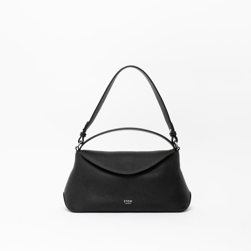 STOW London's East West, detachable shoulder strap and top handle in Black leather on a light grey background featuring silver hardware and details 