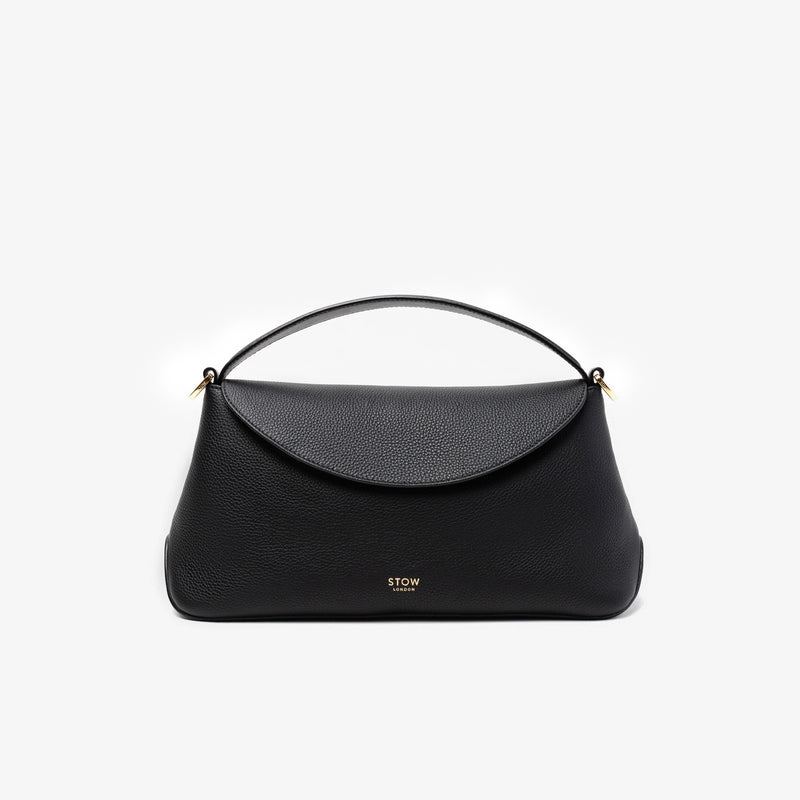 STOW London's East West in Black pebbled leather featuring gold-coated stainless steel hardware on a light grey background