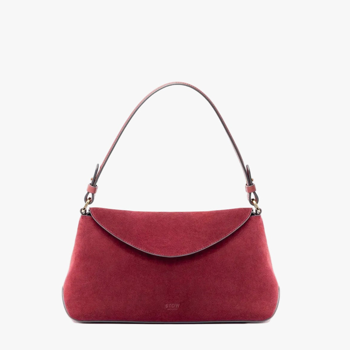 STOW London's East West in Burgundy suede leather on a light grey background featuring the detachable shoulder strap with gold hardware and details 