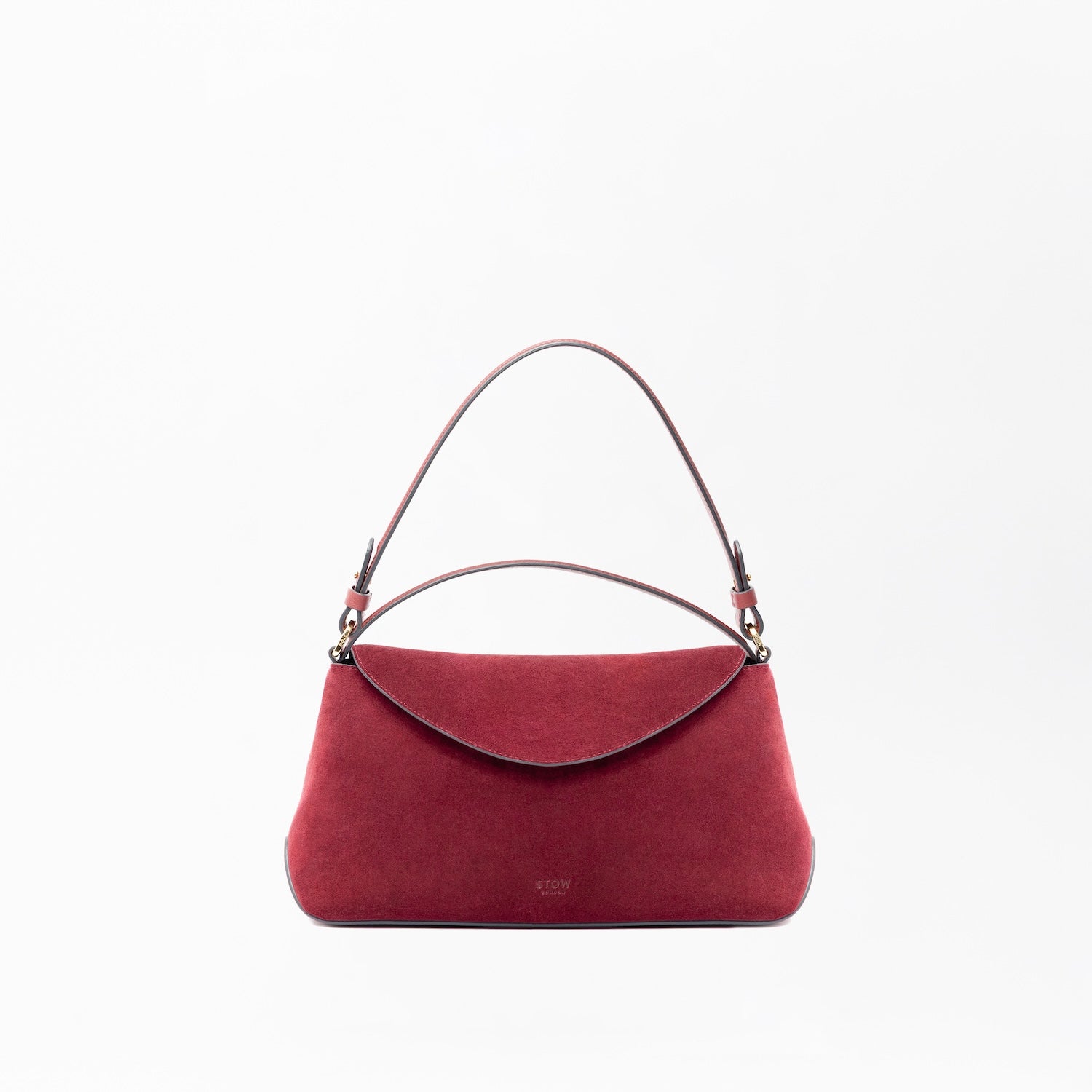 STOW London's East West in Burgundy suede leather on a light grey background featuring the detachable shoulder strap and top handle with gold hardware and details 