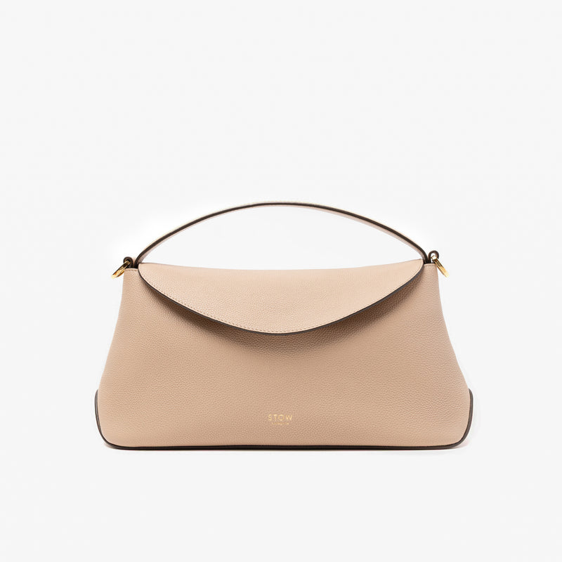 STOW London's East West in Camel pebbled leather featuring gold-coated stainless steel hardware on a light grey background