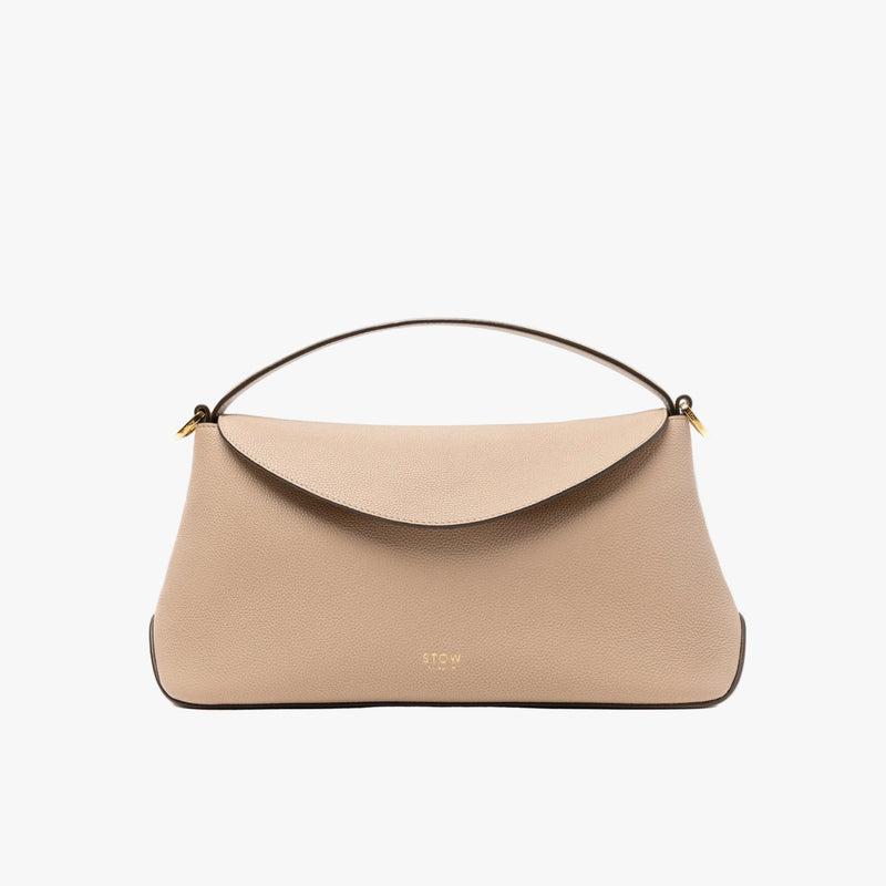 STOW London's East West in Camel pebbled leather featuring gold-coated stainless steel hardware on a light grey background
