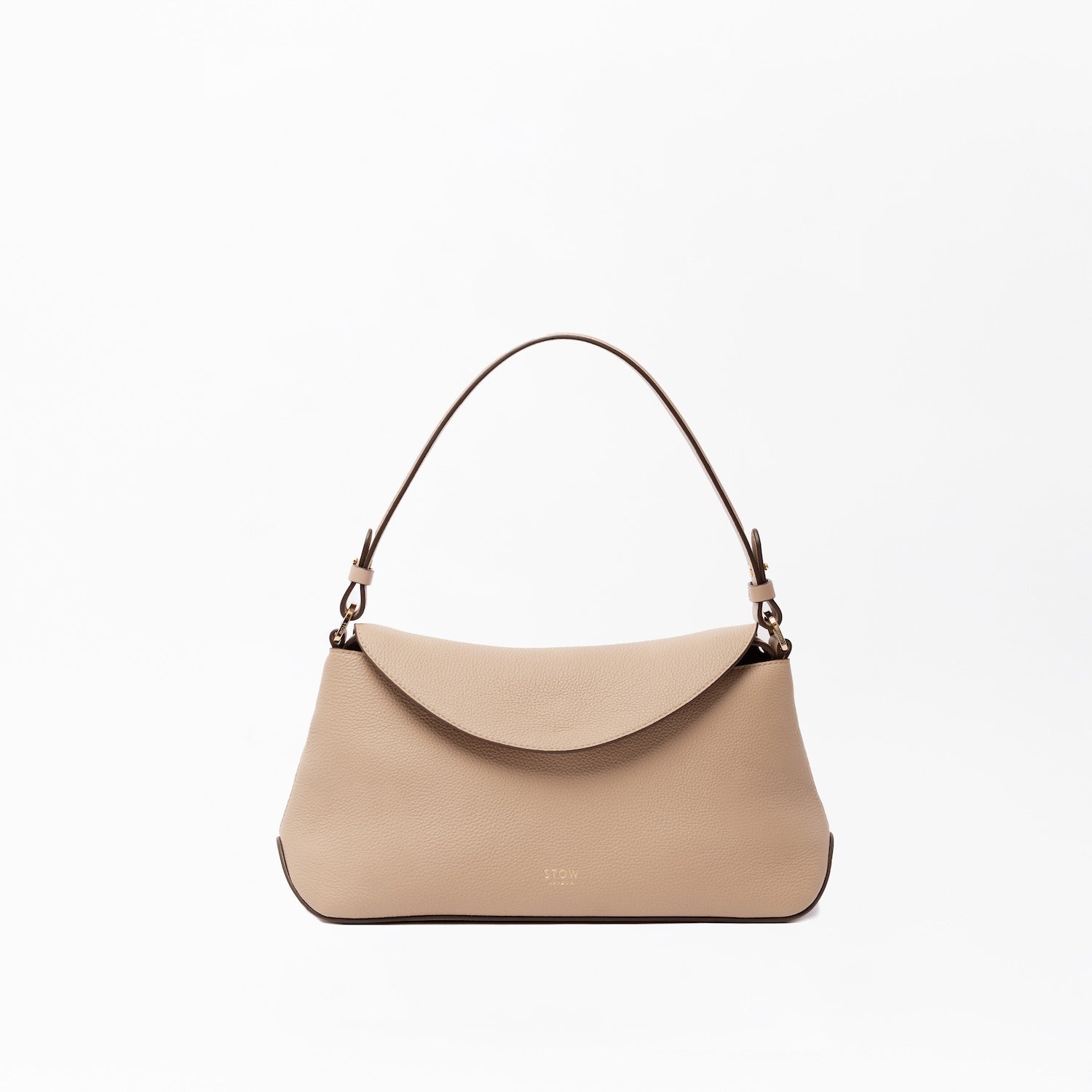 STOW London's East West in Camel leather on a light grey background featuring the detachable shoulder strap with gold hardware and details 
