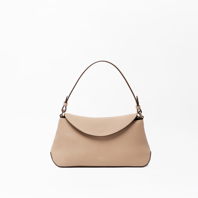 STOW London's East West in Camel leather on a light grey background featuring the detachable shoulder strap with gold hardware and details 