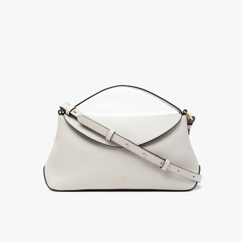 STOW London's East West in Cloud Grey pebbled leather and detachable crossbody strap featuring gold-coated stainless steel hardware on a light grey background