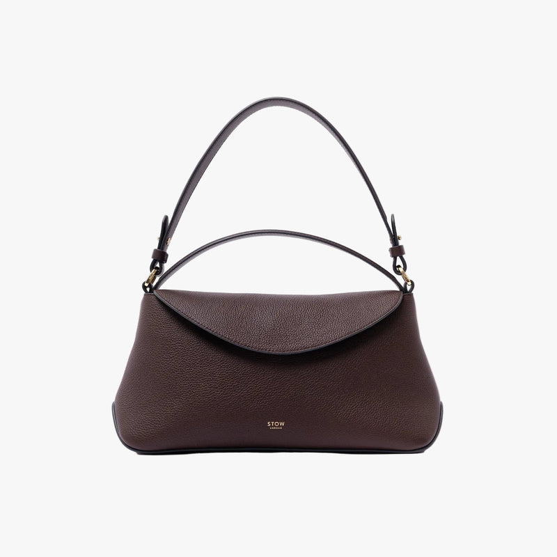 STOW London's East West in Espresso pebbled leather on a light grey background featuring the detachable shoulder strap and gold-coated stainless steel hardware
