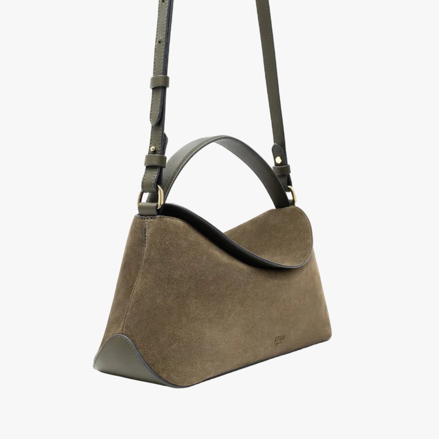 Off-axis view of STOW London's East West in Dark Green suede leather featuring gold-coated stainless steel hardware and detachable crossbody strap on a light grey background