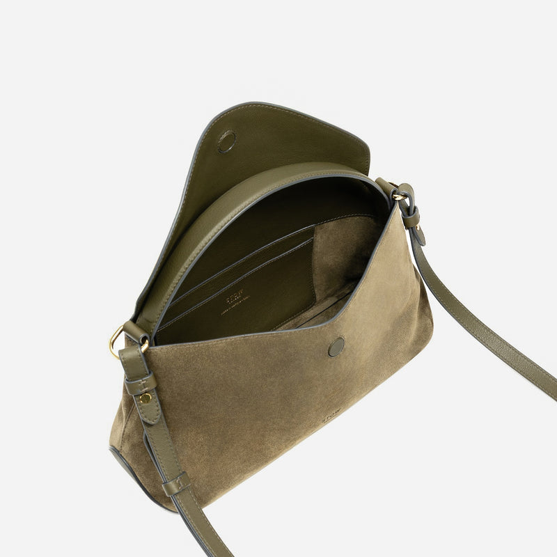 STOW London's East West in Dark Green suede leather with flap open showing the suede interior and slip pocket featuring gold-coated stainless steel hardware and detachable crossbody strap on a light grey background