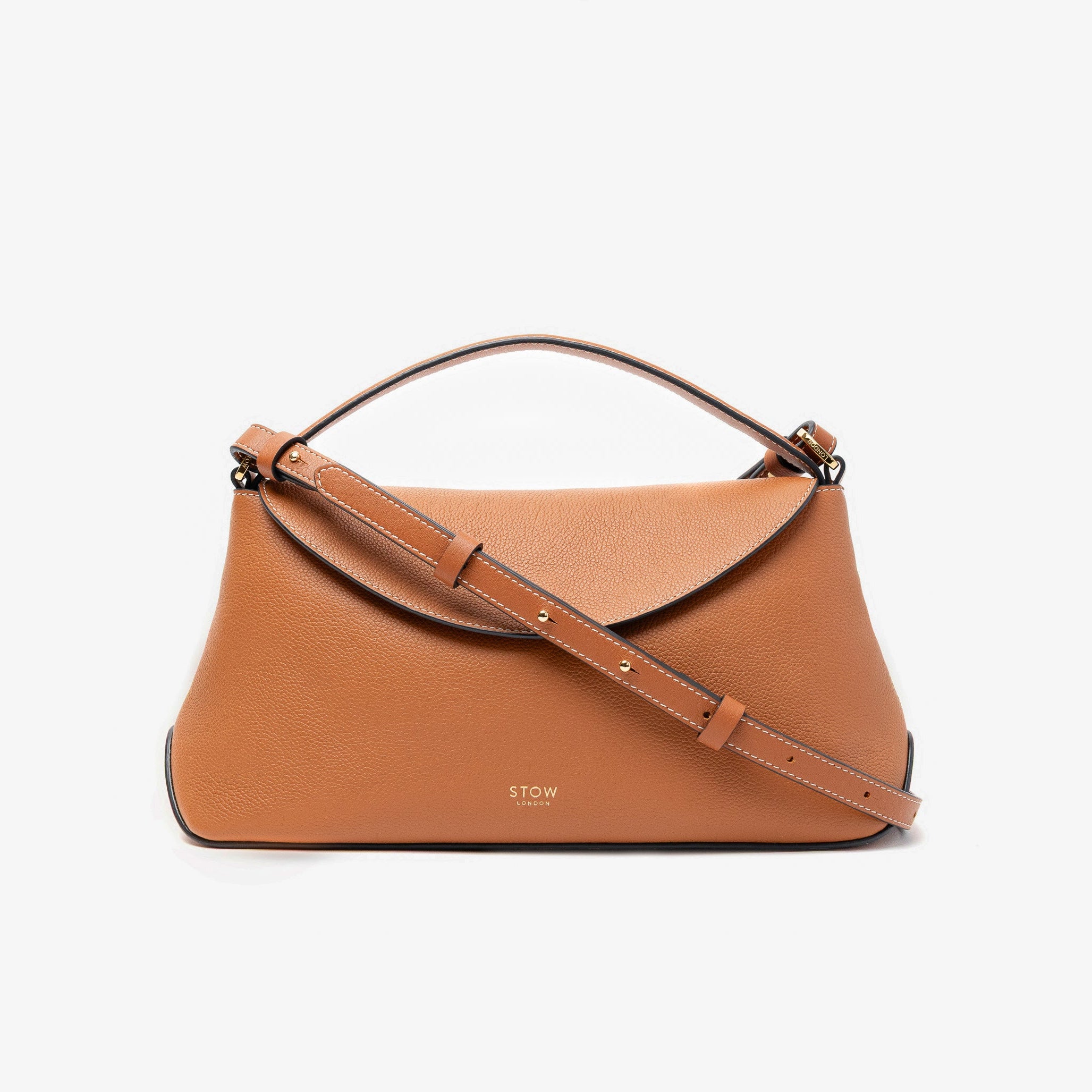 STOW London's East West bag in Earth Tan pebbled leather and detachable crossbody strap featuring gold-coated stainless steel hardware on a light grey background