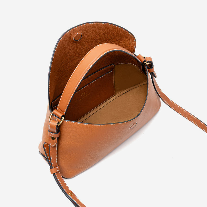 STOW London's East West bag in Earth Tan pebbled leather with flap open showing light beige suede interior and slip pocket featuring gold-coated stainless steel hardware on a light grey background