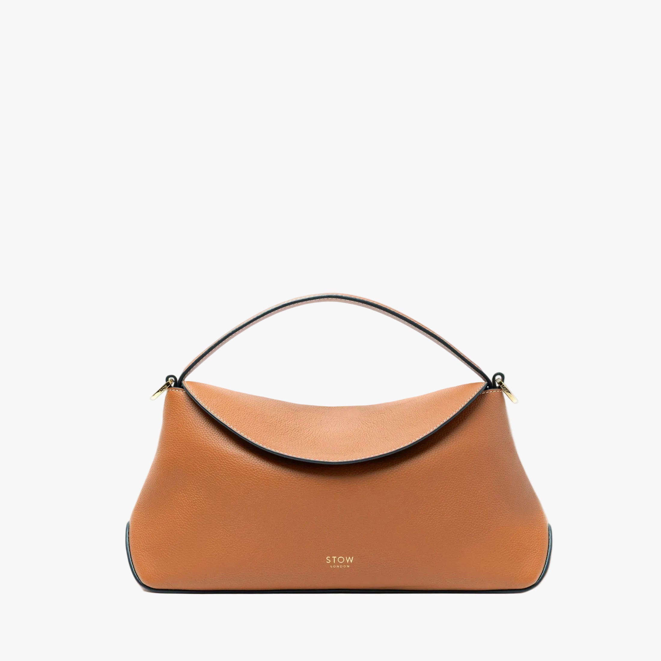 TOW London's East West bag in Earth Tan pebbled leather and crossbody strap featuring gold-coated stainless steel hardware on a light grey background