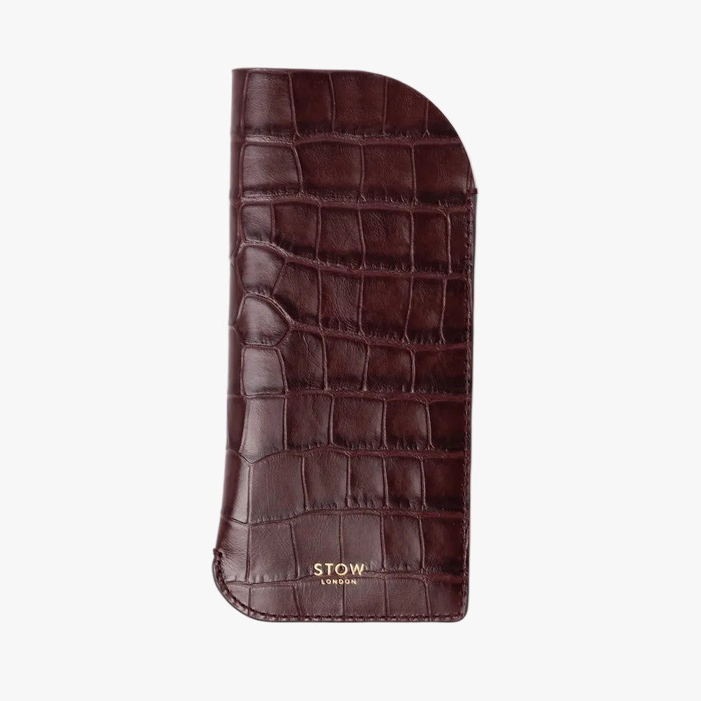STOW London's Glasses Case in Burgundy Embossed Croc leather on a light grey background featuring a small gold embossed logo on the front bottom