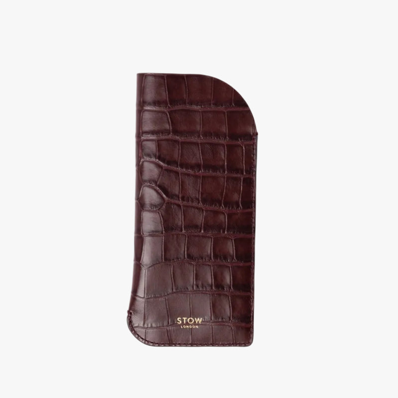 STOW London's Glasses Case in Burgundy Embossed Croc leather on a light grey background featuring a small gold embossed logo on the front bottom