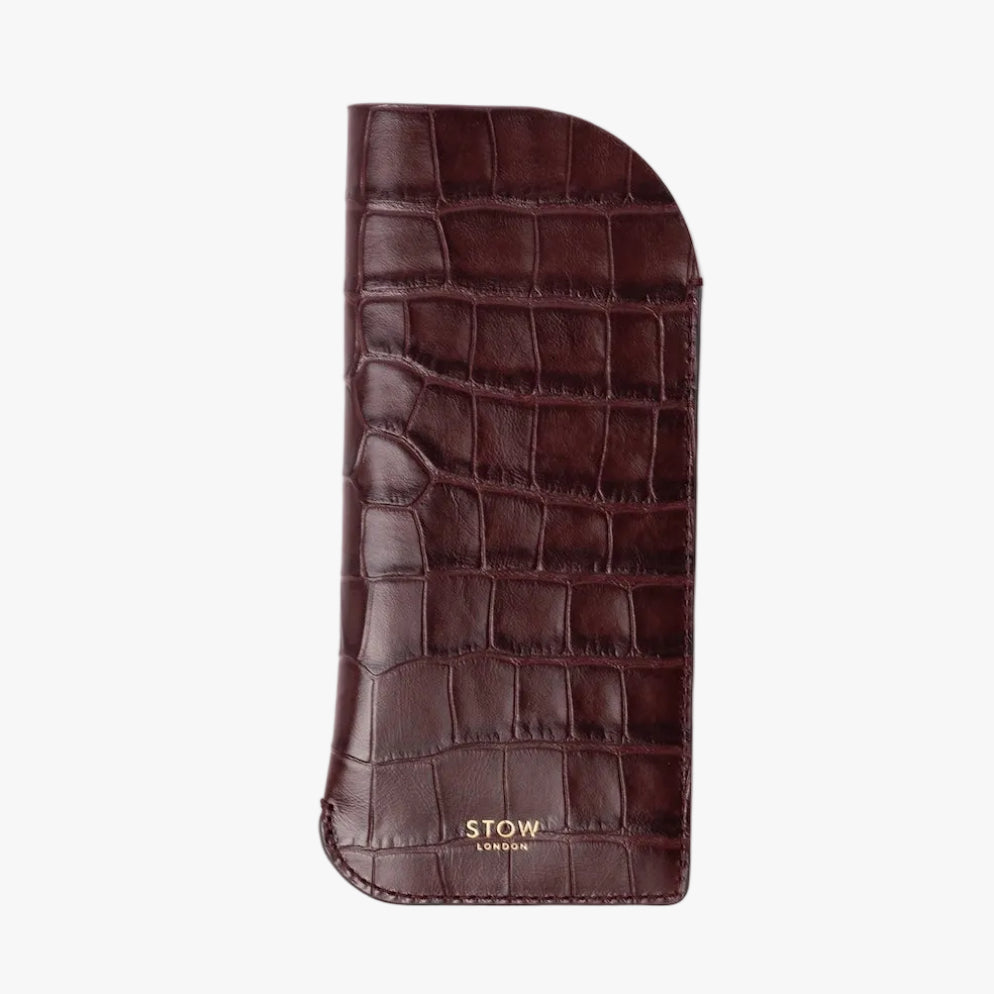 STOW London's Glasses Case in Burgundy Embossed Croc leather on a light grey background featuring a small gold embossed logo on the front bottom