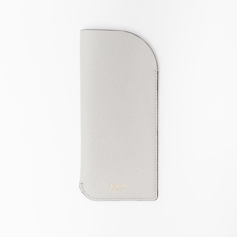 STOW London's Glasses Case in Cloud Grey pebbled leather, featuring a gold logo on a white background
