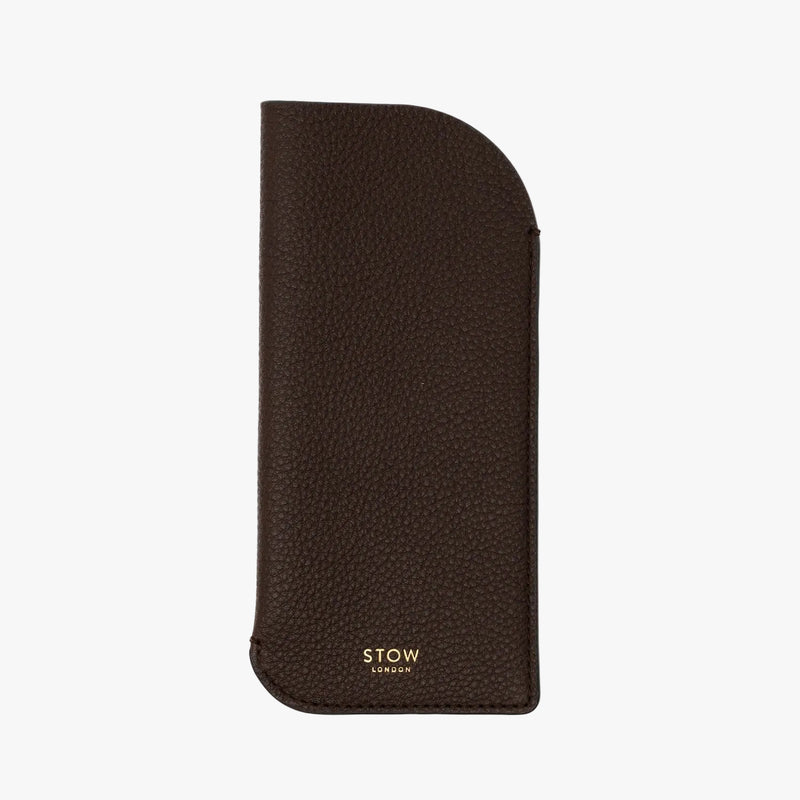 STOW London's Glasses Case in Espresso pebbled leather on a light grey background featuring a small gold embossed logo on the front bottom