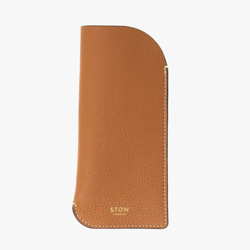 STOW London's Glasses Case in Earth Tan pebbled leather on a light grey background with a small logo on the bottom