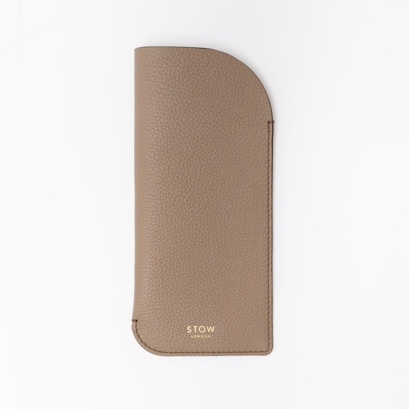 STOW London's Glasses Case in Taupe pebbled leather, featuring a gold logo on a white background