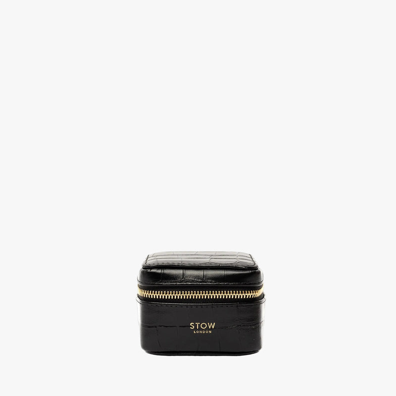 STOW London's Hester Jewellery Case in Black Embossed Croc leather on a light grey background featuring a YKK Natulon zip and fine gold embossed logo on the front