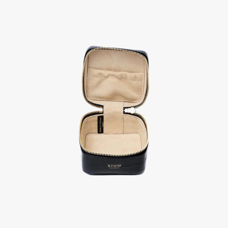 STOW London's Hester Jewellery Case in Black Embossed Croc leather on a light grey background with zipper open showing the light Goat's suede interior and elasticated pocket