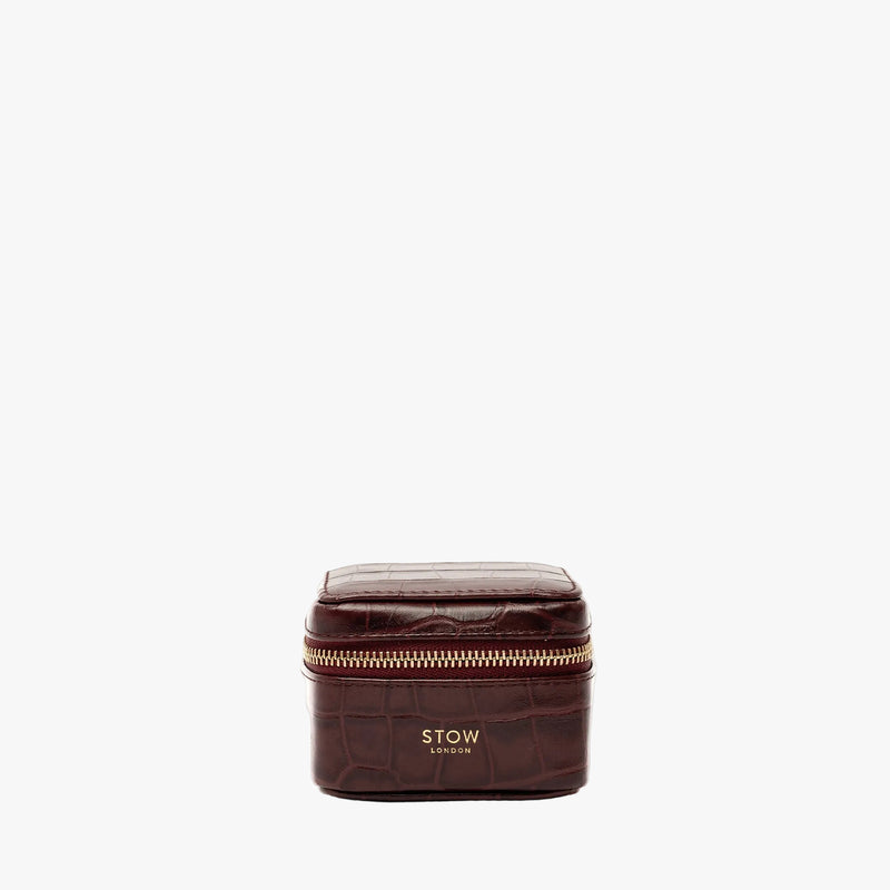 STOW London's Hester Jewellery Case in Burgundy Embossed Croc leather on a light grey background featuring a YKK Natulon zip and fine gold embossed logo on the front