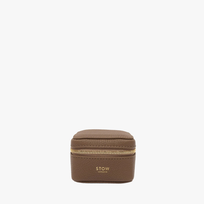 STOW London's Hester Jewellery Case in Mocha pebbled leather on a light grey background featuring a YKK Natulon zip and fine gold embossed logo on the front