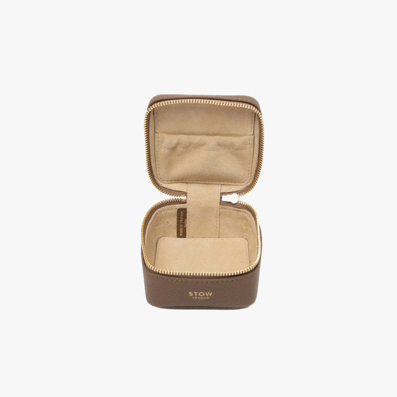 STOW London's Hester Jewellery Case in Mocha pebbled leather on a light grey background with zipper open showing the light Goat's suede interior and elasticated pocket